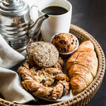 Decadent chocolate croissant on a plate with coffee background