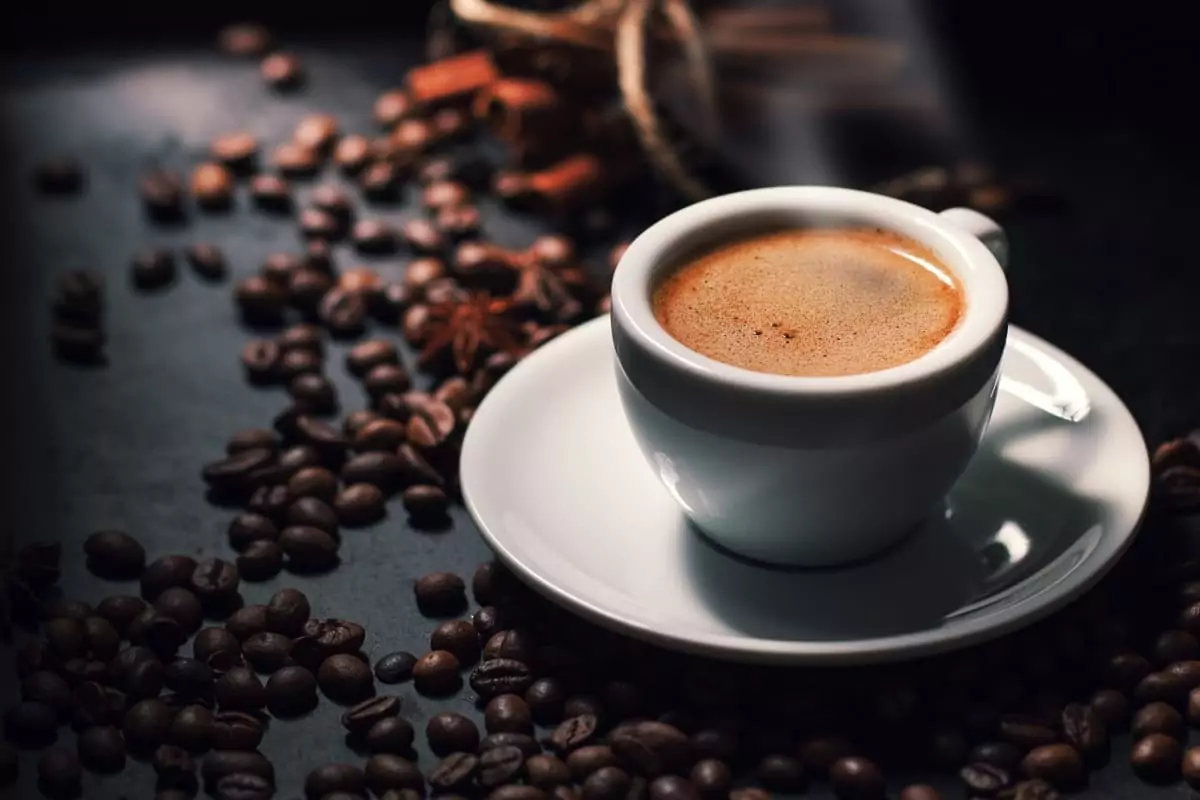 Cappuccino served in a white cup with thick foam and cocoa powder dusting
